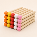 Twenty coloured wooden matchstick pegs in a rainbow mix on a white background